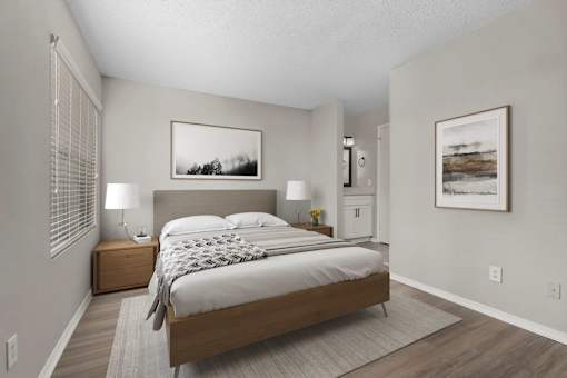 A bedroom with a large bed and two nightstands.