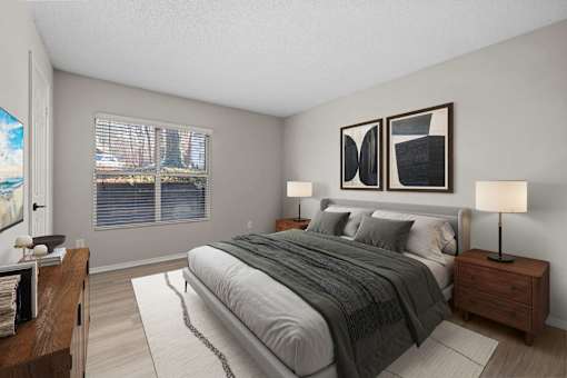 A bedroom with a large bed and two lamps.