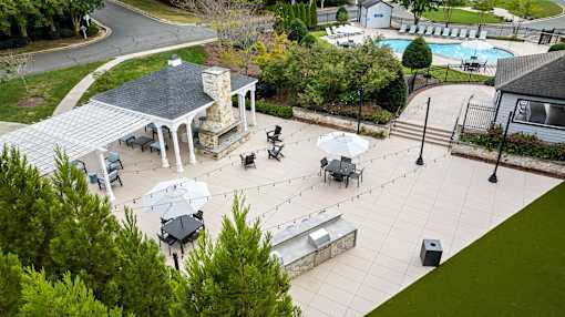 A gazebo is surrounded by tables and chairs in a courtyard.