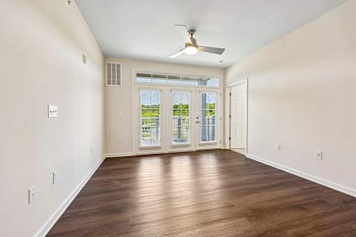 A room with a ceiling fan and wooden flooring.