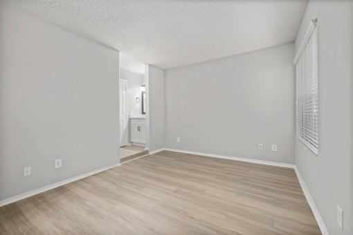 A room with light wood flooring and white walls.