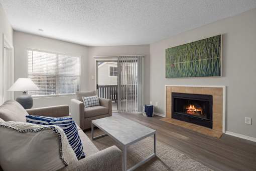 A living room with a fireplace and a painting on the wall.