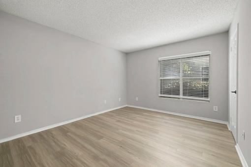 A room with a window and wooden flooring.