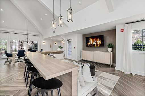 A modern living room with a long wooden table and black chairs.