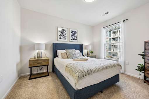 A bedroom with a bed, nightstand, and lamp.