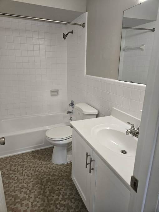 A white toilet sits next to a white sink in a bathroom.