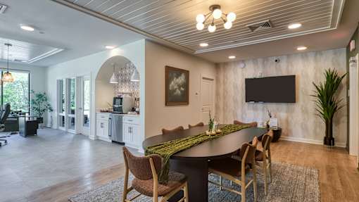 A modern dining room with a large table and chairs.