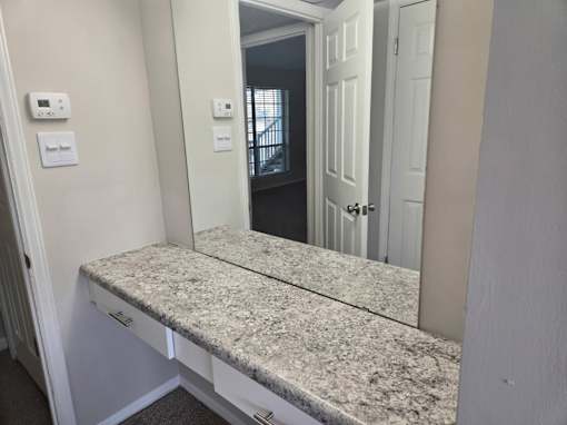 A bathroom with a granite countertop and a door.