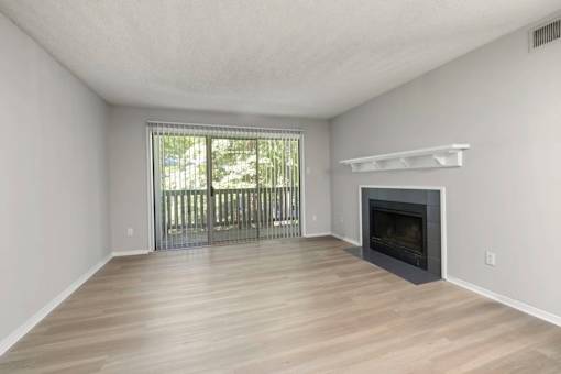 A spacious living room with a fireplace and sliding glass doors.