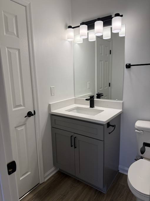 A bathroom with a white sink and a white toilet.