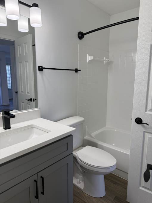 A white toilet sits in a bathroom next to a white sink.