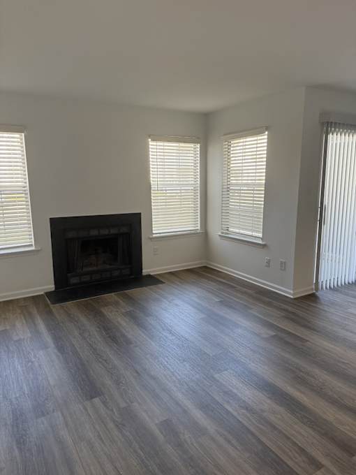 A room with a fireplace and wood flooring.