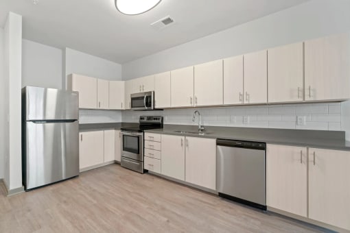 a kitchen with white cabinets and stainless steel appliancesat Metropolis Apartments, Glen Allen, VA