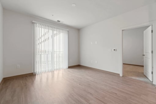 spacious living room with wood flooring and sliding glass door to bedroomat Metropolis Apartments, Glen Allen