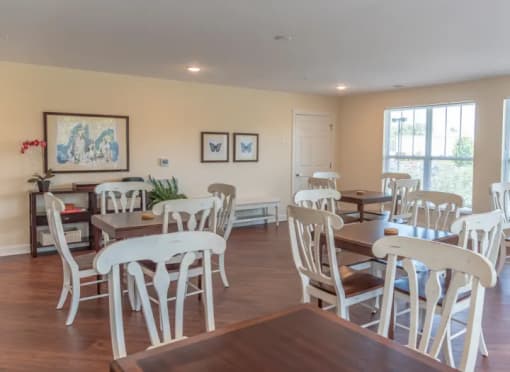 a dining room with white chairs and tables