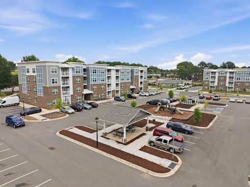 A parking lot with cars and a building in the background.