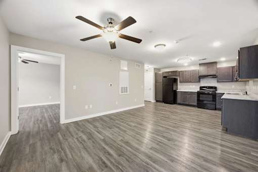 A room with a ceiling fan and wooden flooring.