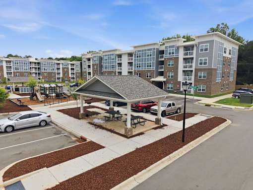 A covered picnic area in front of apartment buildings.