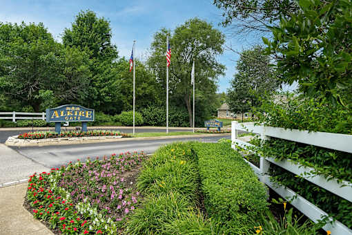 A sign that says "ALICE" is in front of a white fence.