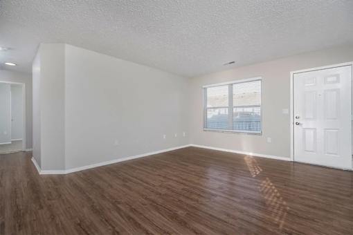 A room with wooden flooring and white walls.
