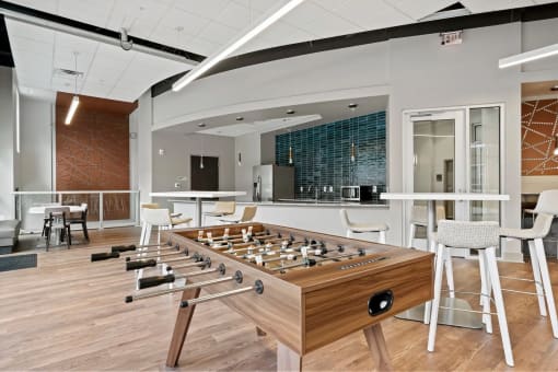 a foosball table in a room with chairs and a barat Metropolis Apartments, Virginia, 23060
