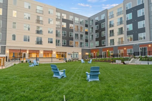 an office building with a courtyard with green grass and chairsat Metropolis Apartments, Glen Allen, 23060