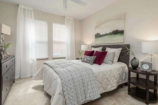 A bedroom with a large bed and a ceiling fan.