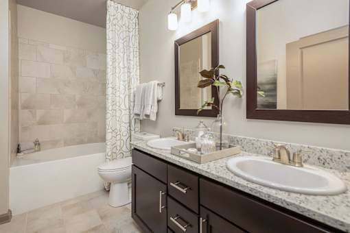 A bathroom with a white toilet and a white bathtub.