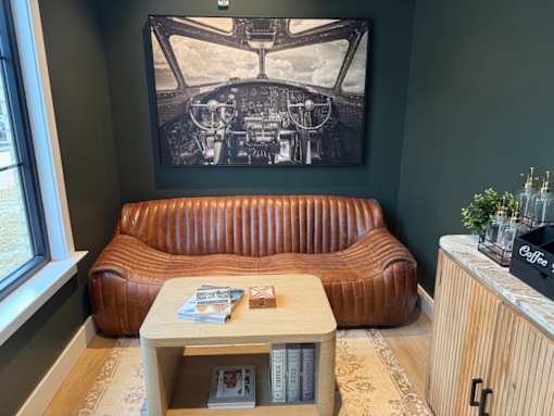 A brown leather sofa with a coffee table in front of it.