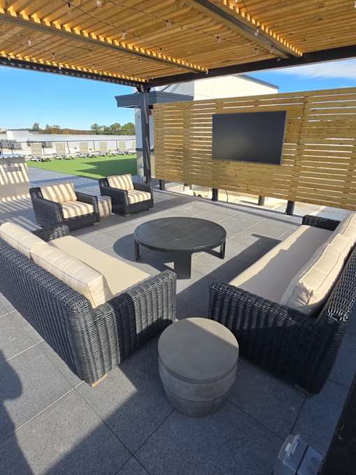A patio with a table, chairs and a television.