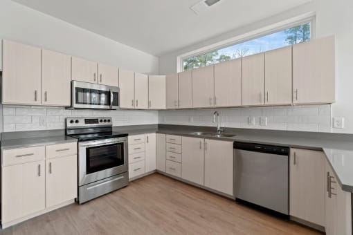 a kitchen with white cabinets and stainless steel appliancesat Metropolis Apartments, Virginia, 23060