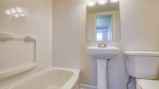 a white bathroom with a sink toilet and a tub at Gates of West Bay in Norfolk, VA 
