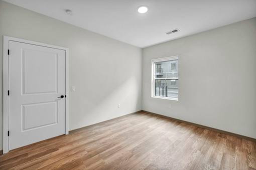 A room with a white door and a window with blinds.