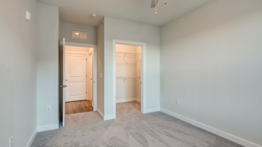 an empty bedroom with a closet and a door to a bathroom at The Bella at Westchester, Midlothian, VA