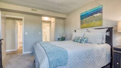 a bedroom with a large bed and a painting