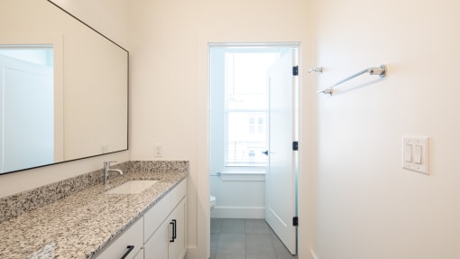 a bathroom with granite countertops and a large mirror at Ainsworth, Richmond, Virginia