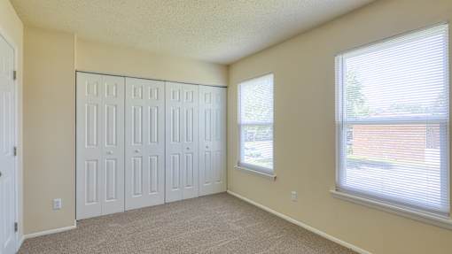 A room with a white door and a window with blinds.