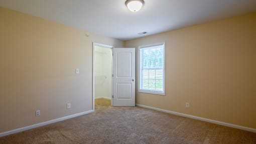 a room with carpet and a door and a window