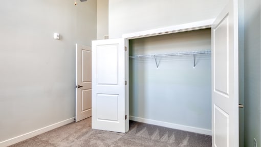 an empty closet in a home with a white door and a door to a closet at The Bella at Westchester, Midlothian