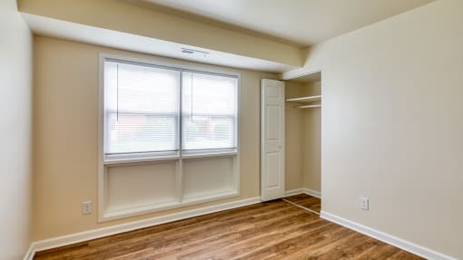 an empty bedroom with a window and a closet at Gates of West Bay in Virginia 23503