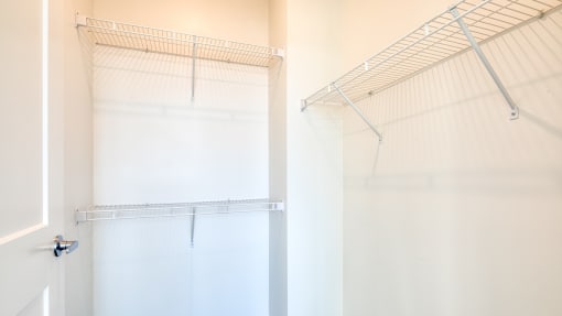 a walk in closet with white walls and a white closet door with a mirrored closet at The Port at East Beach Apartments and Marina, Norkfolk