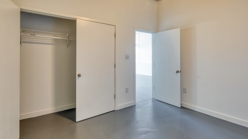 an empty room with a closet and two doors