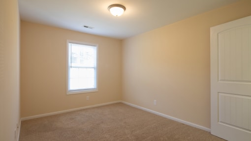 a bedroom with a white door and a window