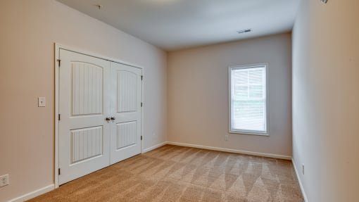 an empty living room with two doors and a window