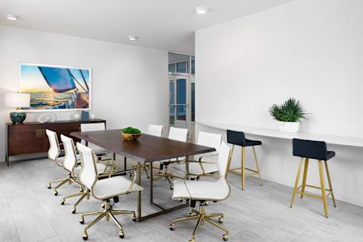 A modern dining room with a wooden table and white chairs.