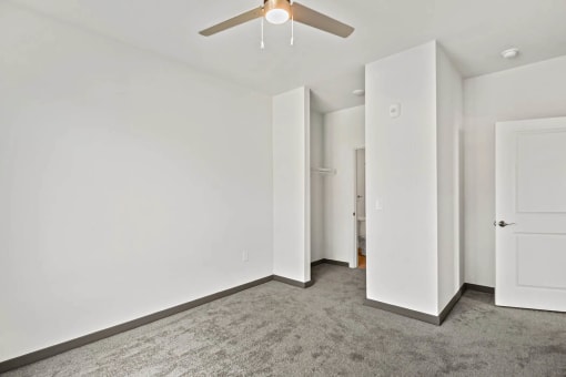 a living room with white walls and a ceiling fanat Metropolis Apartments, Glen Allen, VA