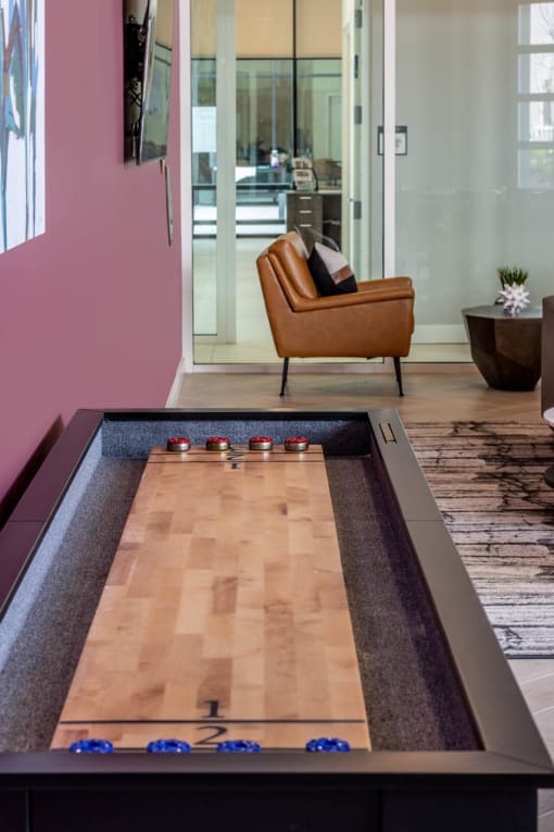 Enjoy a game of shuffleboard at the Resident Lounge and Social Space Centro at Pine Nash, Wilson, NC
