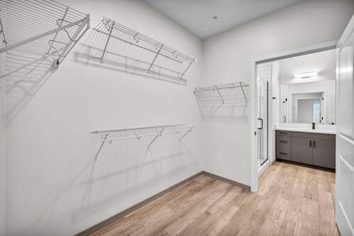 A white laundry room with a wooden floor and a white door.