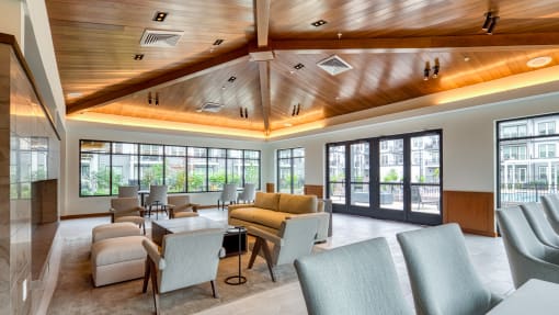 a lobby with couches chairs and tables and windows at Ainsworth, Richmond, Virginia