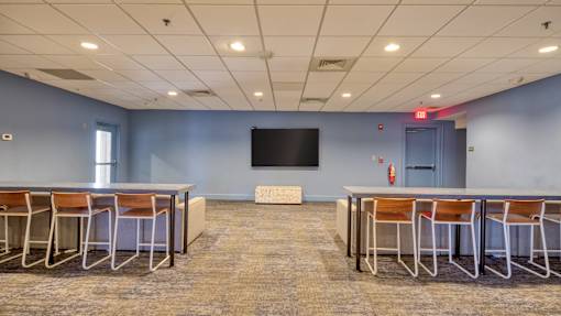 A conference room with a large table and chairs.